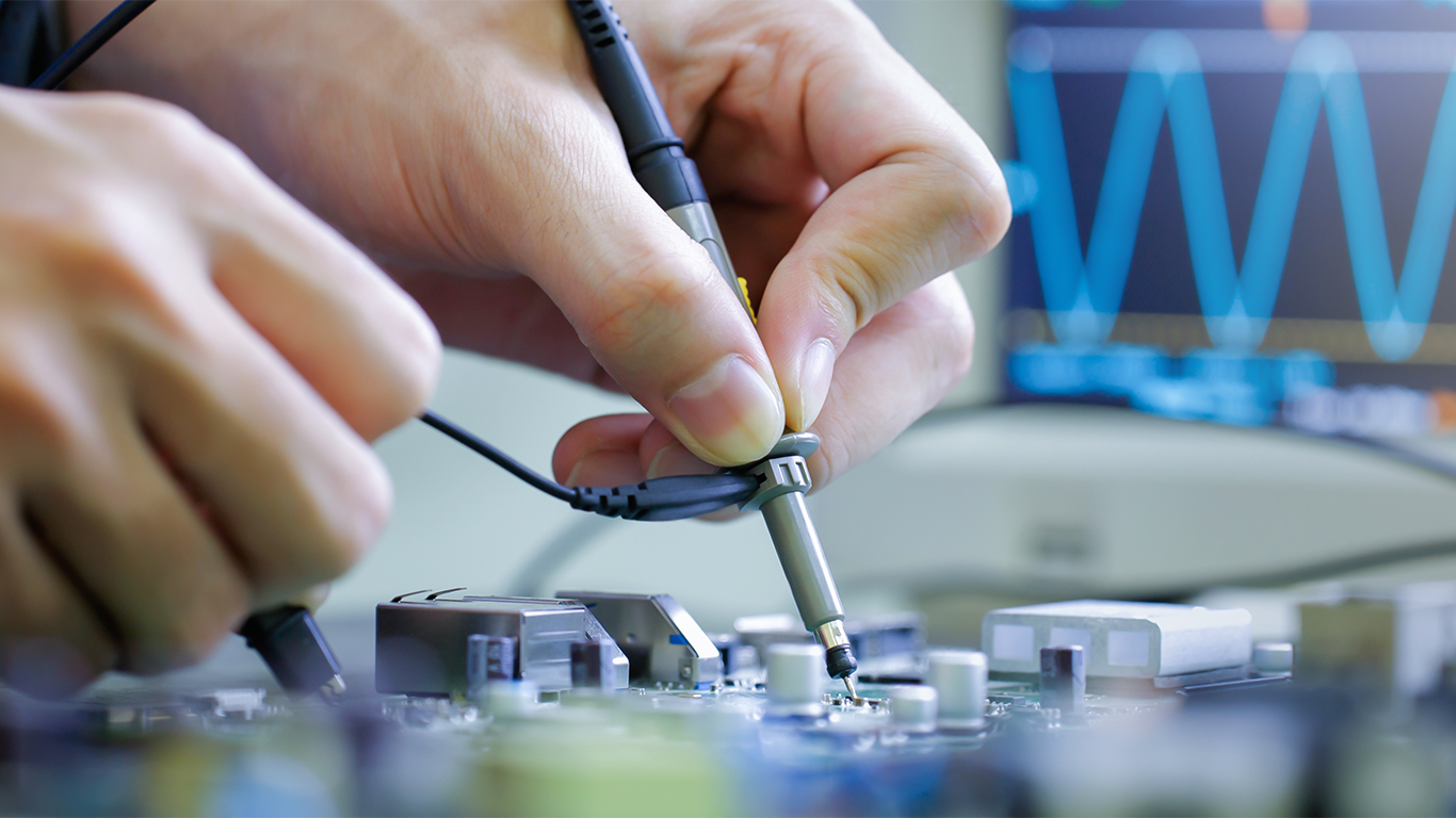 Closeup photo of hands reparing an electronic device.