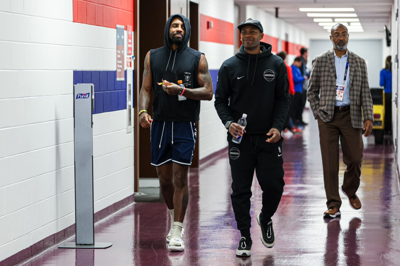 USCA alumnus Rico Hall (right) walks alongside Mavericks player Kyrie Irving (left)