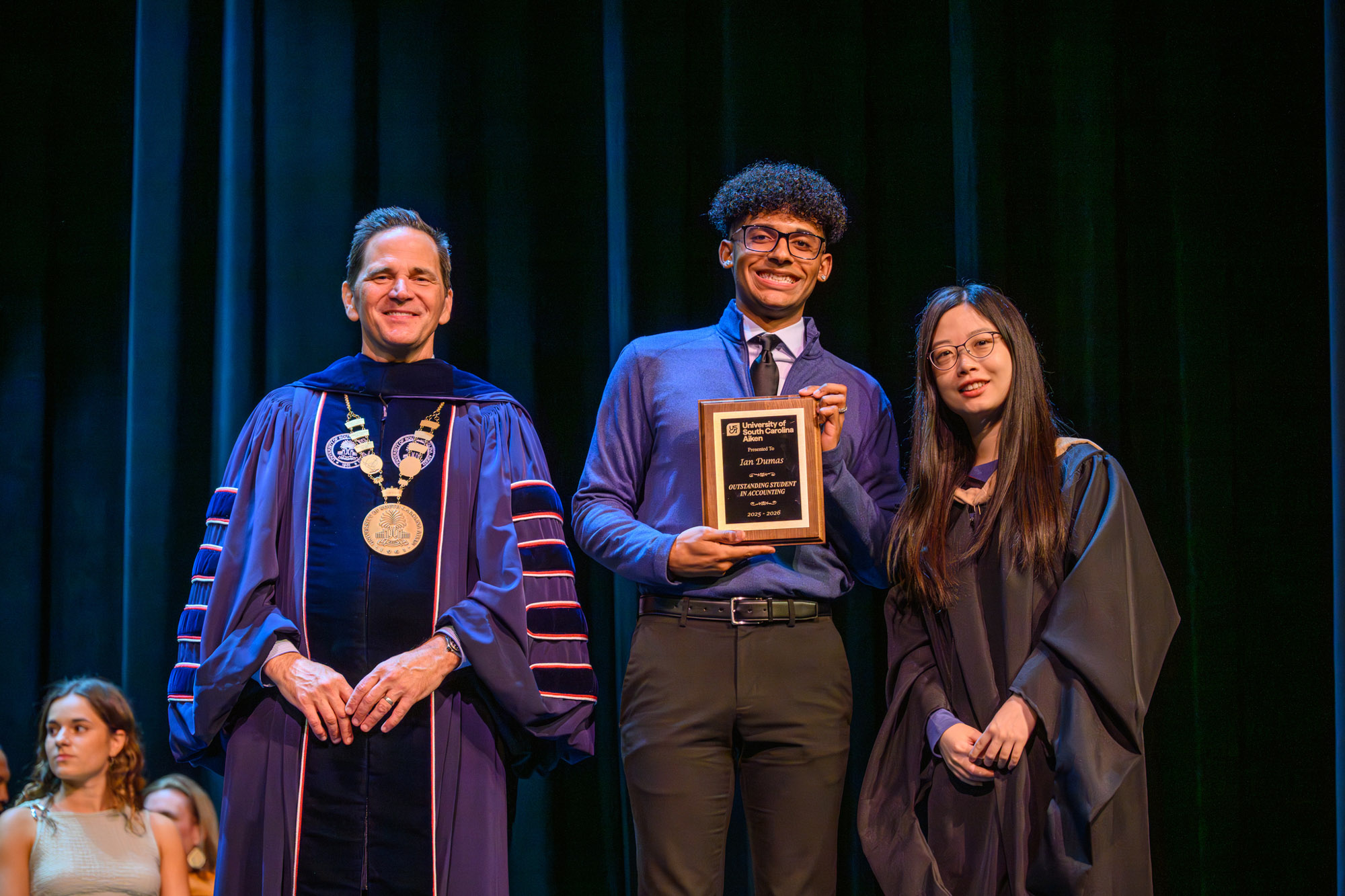 Ian Dumas, center, receives the Outstanding Student in Accounting award from Chancellor Daniel Heimmermann, left, and Dr. Yu Cao, associate professor in the USCA School of Business Administration. USCA held its annual Academic Honors Ceremony on May 5 in the Etherredge Center, recognizing students from across the campus for their academic excellence.